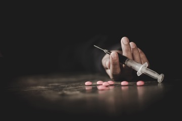 Рука со шприцом в темноте